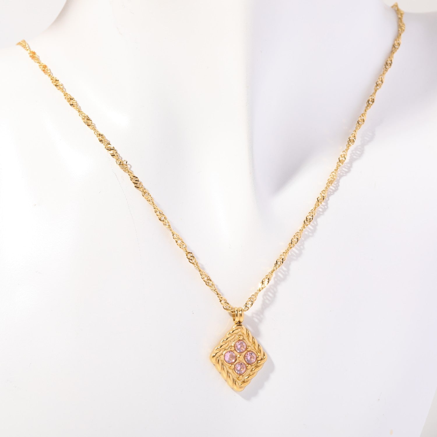 Birthstone necklace with four soft pink crystals in a twisted gold rope frame, worn on a display bust