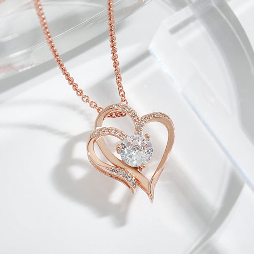 Rose gold double heart pendant close up, the centre solitaire catching the light