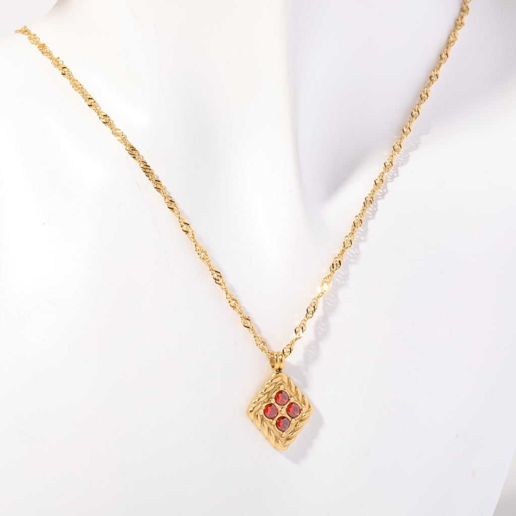Birthstone necklace with four red crystals in a twisted gold rope frame, worn on a display bust