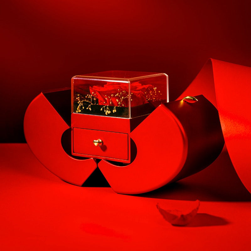 Apple-shaped rose gift box split open into petals, showing the clear rose case and the small jewelry drawer beneath