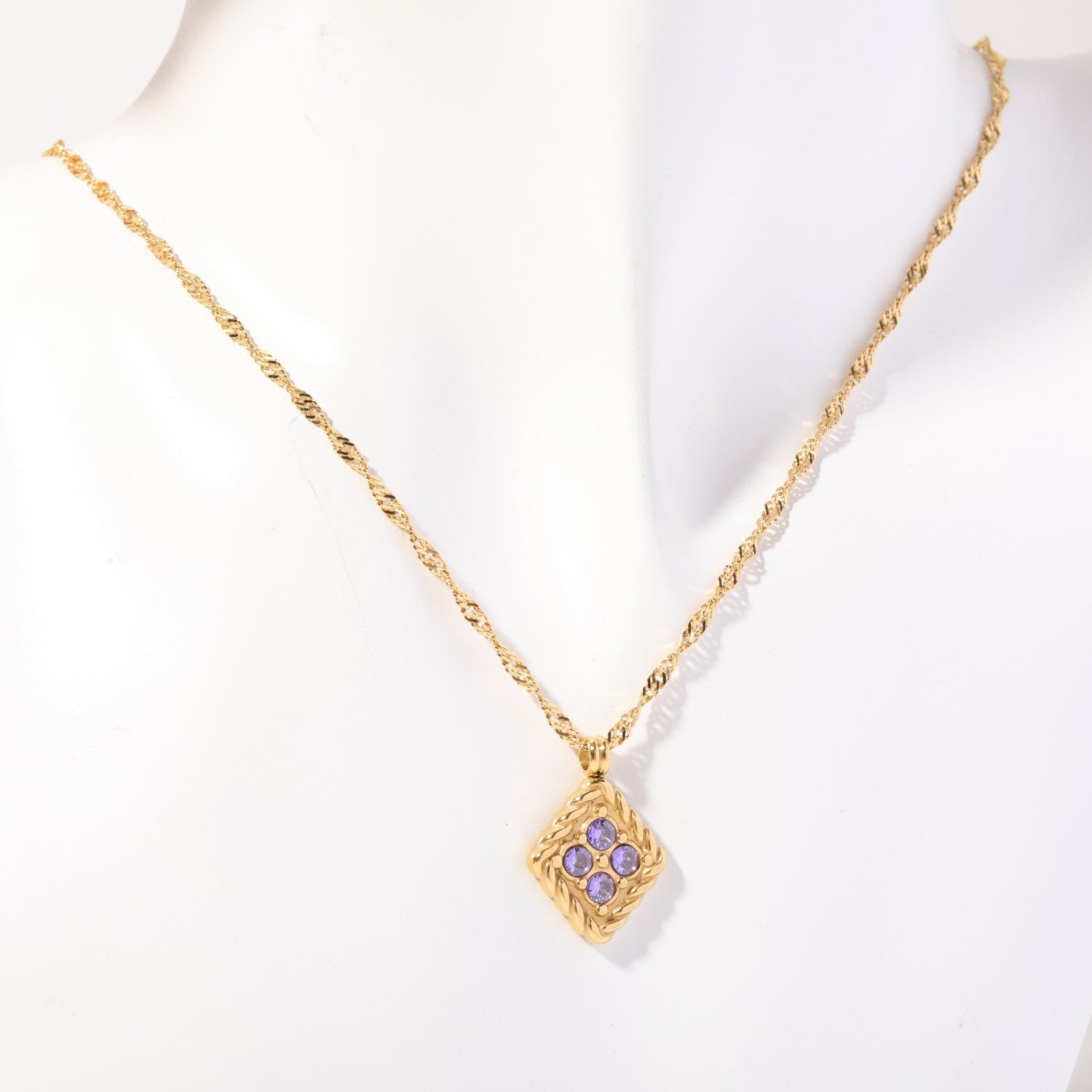 Birthstone necklace with four lilac crystals in a twisted gold rope frame, worn on a display bust